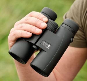 a hand holding Opticron Adventurer II binoculars